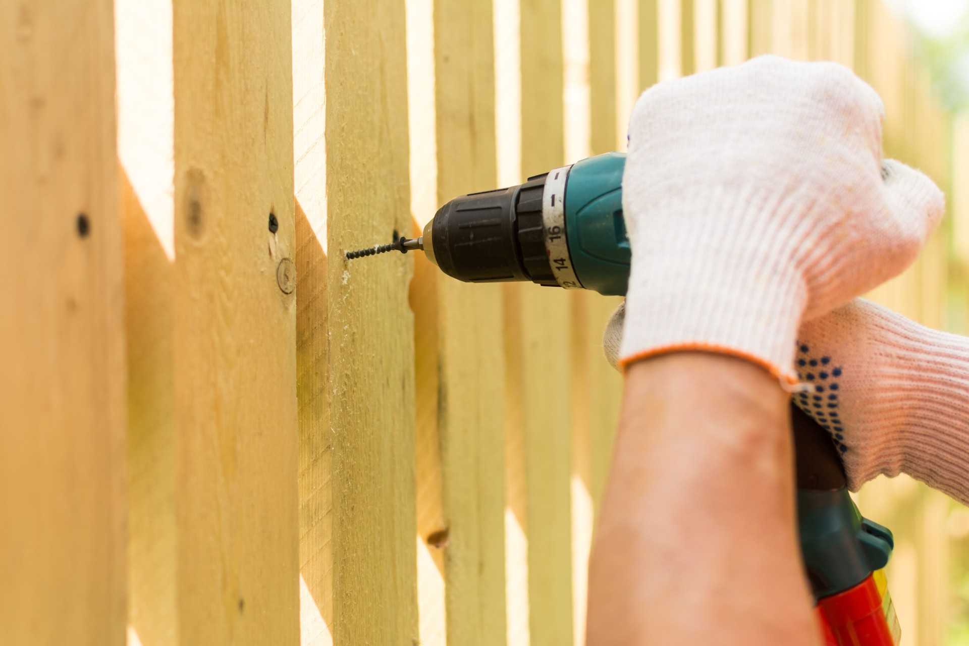 Hands of the carpenter holding electric screwdriver